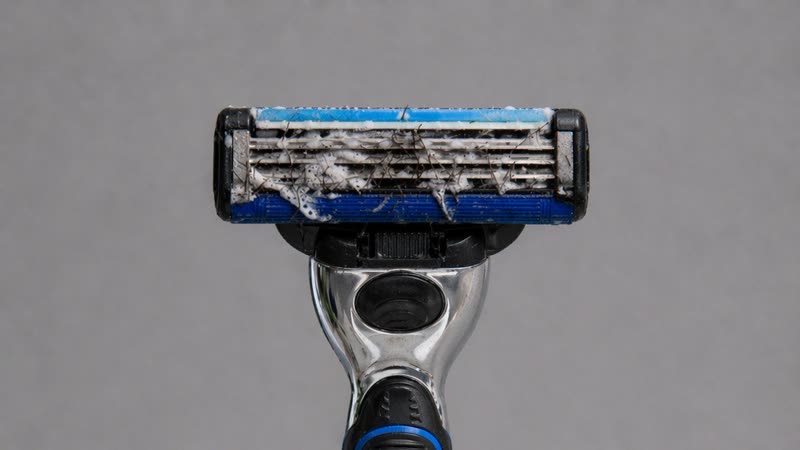 Cartridge razor blade clogged with hair and shaving foam after several passes